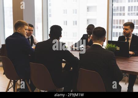 Silhouettes of people sitting at the table. A team of young businessmen working and communicating together in an office. Corporate businessteam and Stock Photo
