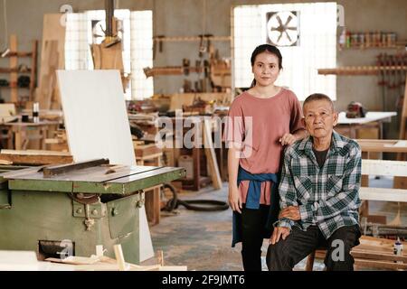 Asian senior man and his daughter working in family carpenters workshop Stock Photo