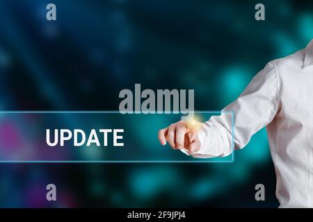 Male hand pressing the word update on a virtual search display bar. Business, internet, software technology concept. Stock Photo