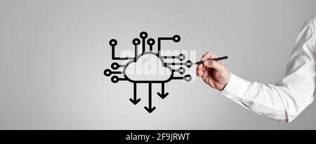Businessman draws a download icon with computer processor chip on gray background. Cloud computing concept. Stock Photo