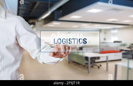 Male hand pressing the word logistics on a virtual search display bar. Stock Photo