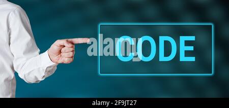 Male hand points to the word code. Technology software development or business rules of conduct concept. Stock Photo