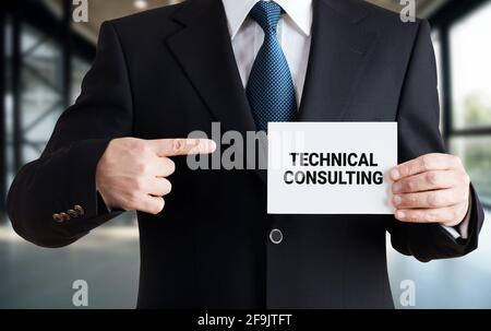 Businessman shows a card with the message technical consulting. Customer care and technical service support concept. Stock Photo