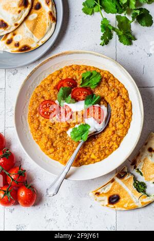 Vegan lentil soup with cilantro and tomatoes. Dal soup with tomatoes. Indian cuisine concept. Stock Photo