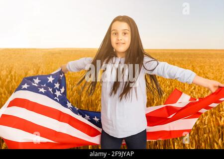 Little kid with the American flag on his back Stock Photo