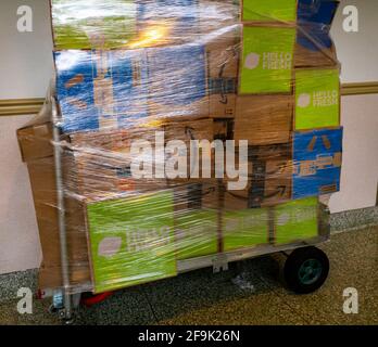 A shrink-wrapped handcart towering with packages from Amazon, Walmart and Hello Fresh among others sits unattended in an apartment building lobby the Chelsea neighborhood  of New York on Saturday, April 17, 2021. (Photo by Richard B. Levine)