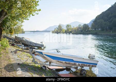 Docked boats on the lake Como district in Italy on sunny day. Alp mountains. Lecco, Italy - October 17, 2020 Stock Photo