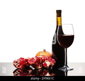 Isolated wine bottle, wine glass and juicy pomegranate on a white background Stock Photo