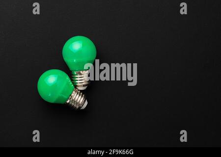 Two green light bulbs on black background Stock Photo