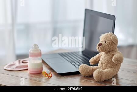 baby milk formula, laptop, soother and teddy bear Stock Photo