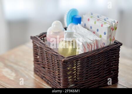 baby things in basket on wooden table at home Stock Photo