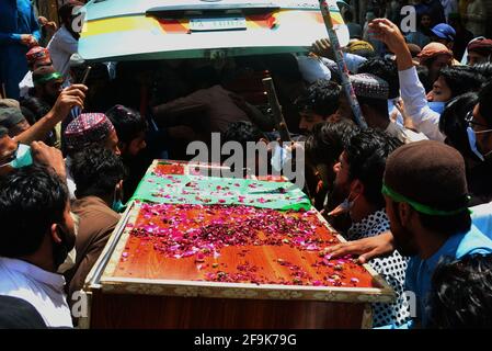 Lahore, Pakistan. 19th Apr, 2021. Supporters of Tehreek-e-Labbaik Pakistan (TLP) party carry the coffin and shout slogans during the funeral prayer of their colleague of a comrade who was killed in the Sunday's clash with security forces, a protest after their leader was detained following his calls for the expulsion of the French ambassador in Lahore. (Photo by Rana Sajid Hussain/Pacific Press) Credit: Pacific Press Media Production Corp./Alamy Live News Stock Photo