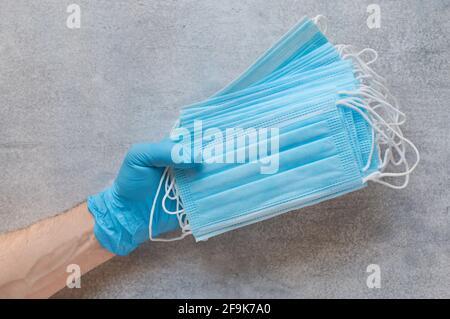 Stack of disposable medical protective masks in the hand Stock Photo