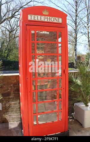 K6 telephone box designed by Giles Gilbert Scott grade 2 listed in Upholland with full size wooden painted soldier in red black and gold uniform in Stock Photo