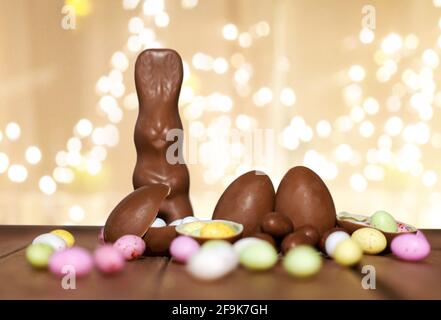 chocolate eggs, easter bunny over festive lights Stock Photo