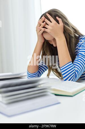 stressed student girl with books learning at home Stock Photo