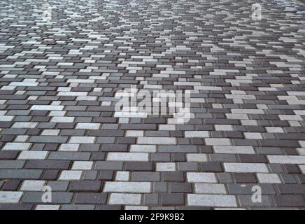 beautiful background laid paving slabs on pedestrian path. Monotonous pattern of multicolored glazed paving slabs. Photo with paving slabs with small Stock Photo
