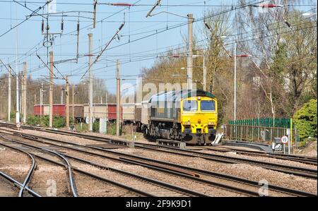 Freightliner class 66 diesel locomotive waits with stone wagons in a siding at Hitchin, Hertfordshire, England, UK Stock Photo