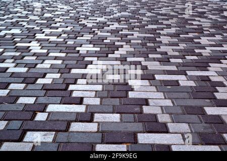 beautiful background laid paving slabs on pedestrian path. Monotonous pattern of multicolored glazed paving slabs. Photo with paving slabs with small Stock Photo