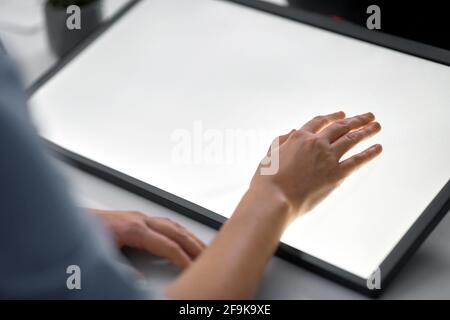 hand on led light tablet at night office Stock Photo
