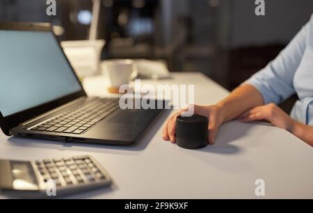 hand using smart speaker at night office Stock Photo