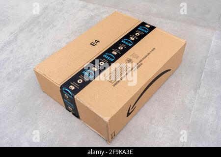 Nice, France- 14.04.2021: View from above of Amazon Prime logotype printed on cardboard box security scotch tape on the front. Gray background. High q Stock Photo