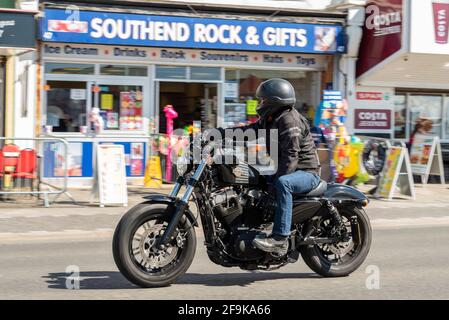 Harley Davidson Forty Eight motorcycle, motorcyclist riding in Southend on Sea, Essex, UK, on a sunny, bright Spring day. Passing Southend Rock shop Stock Photo
