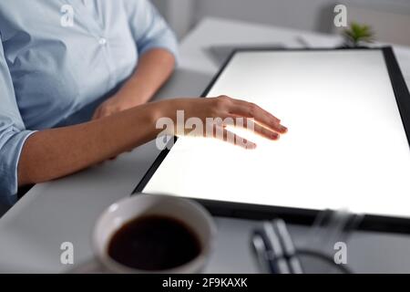 hand on led light tablet at night office Stock Photo