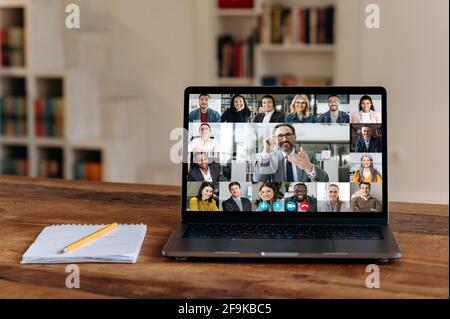 Virtual meeting.View at laptop screen with group of business people of different nationalities gathered from different parts of the world for communication and discussion business issues by video call Stock Photo