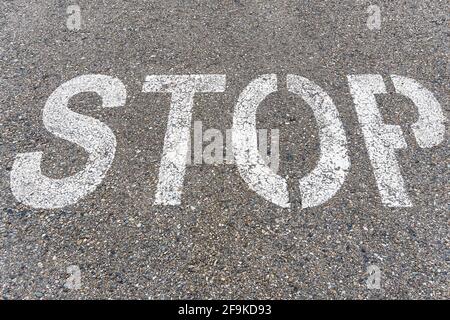 STOP a large inscription on the asphalt in full screen. Stock Photo