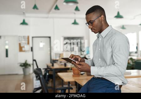 Young African businessman using a tablet at his office desk Stock Photo