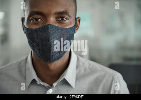 Young African businessman wearing a face mask at work Stock Photo
