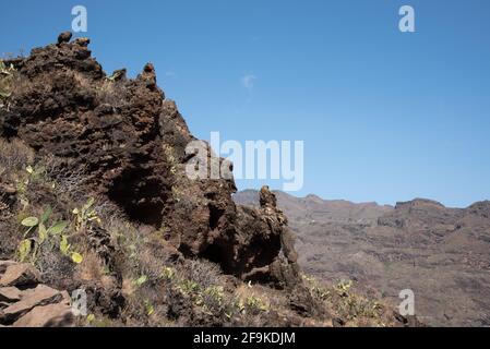 Guarimiar gorge is a steep lava rock canyon at the south of La Gomera in the Canary Islands  in a dry landscape with sparse opuntia and agave plants. Stock Photo