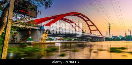 Beautiful sunset on Binh Loi Bridge new and old by night in the rush hour, Ho Chi Minh City, Vietnam. Travel and landscape concept. Stock Photo