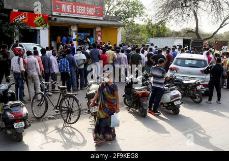 New Delhi, India. 19th Apr, 2021. People flout social distancing norms as they stand in queue to buy liquor at a wine and liquor store ahead of the 7 days lockdown imposed by New Delhi government.Delhi Chief Minister Arvind Kejriwal announces to impose a lockdown from 10pm tonight for 7 Days to tackle the rising Covid-19 cases in the capital city. (Photo by Naveen Sharma/SOPA Images/Sipa USA) Credit: Sipa USA/Alamy Live News Stock Photo