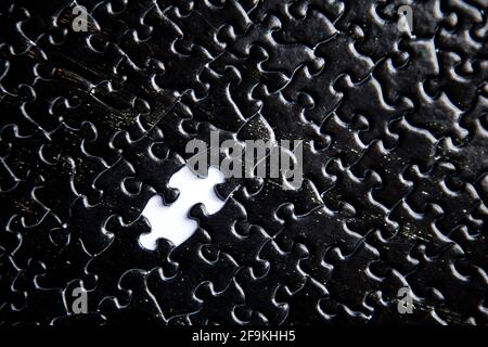Black jigsaw puzzle pieces background with missing piece Stock Photo