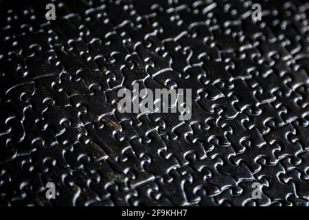Black textured jigsaw puzzle pieces background Stock Photo