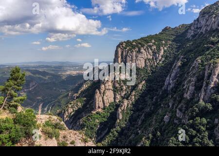 View of mountains and plains surrounding Abbey of Montserrat (Santa Maria de Montserrat) in Catalonia, Spain (Vertical photo) Stock Photo