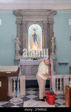 Woman mopping floor in church, Gibraltar Stock Photo