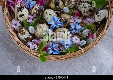 Happy Easter. Wicker basket with Easter eggs and spring bright flowers Stock Photo