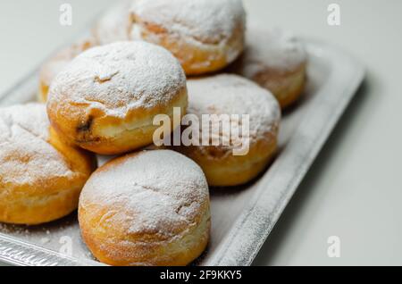 Berliner Pfannkuchen, a German donut, traditional yeast dough deep fried filled with chocolate cream and sprinkled with powdered sugar, sweetness on a Stock Photo