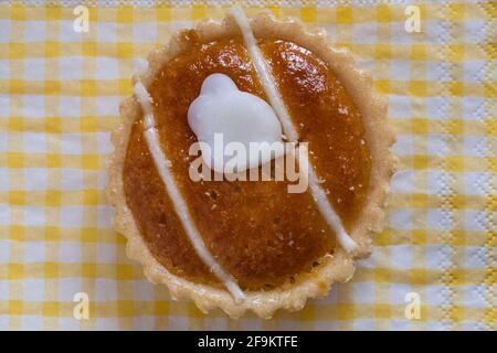 Belgian Frangipans almond flavoured cake set on yellow and white checked serviette napkin Stock Photo
