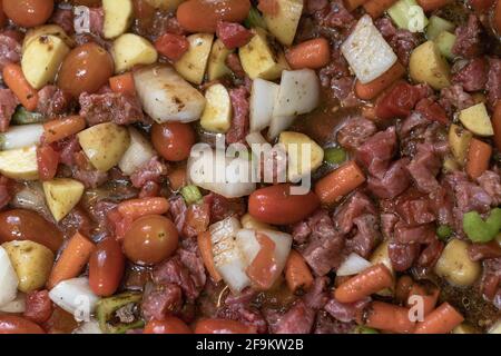Oven-Baked Beef Stew in a casserole dish. Has tomatoes, onions, stew beef, celery carrots, and potatoes. Stock Photo