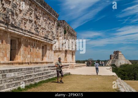UXMAL, MEXICO - FEB 28, 2016: Tourists visit the ruins of the Palacio del Gobernador Governor's Palace building in the ruins of the ancient Mayan city Stock Photo