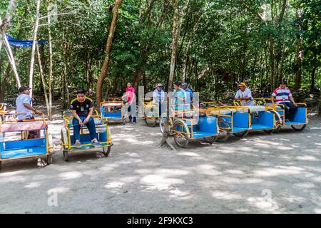 COBA, MEXICO - MARCH 1, 2016: Pedi-trikes bicycle taxi riders wait for tourists at the ruins of the Mayan city Coba, Mexico Stock Photo