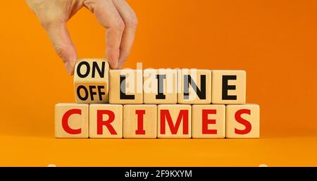 From offline to online crimes. Businessman turns a cube and changes the words 'offline crimes' to 'online crimes'. Beautiful orange background. Copy s Stock Photo
