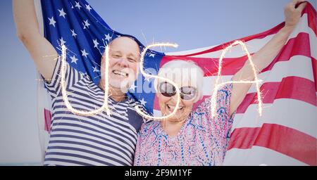 Composition of sparkling usa text over senior couple holding american flag Stock Photo