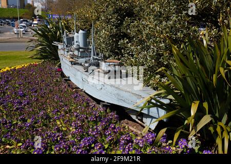 A retired remote controlled battleship used in the naval warfare shows at Peasholm Park in Scarborough, now sits on a roundabout outside the park. Stock Photo