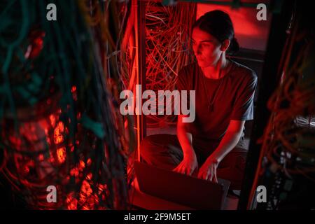 High angle portrait of young woman wearing military uniform while using computer in server room Stock Photo