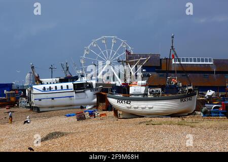 Fishing boats on The Stade shingle beach, Hastings Ferris Wheel in background, Hastings, East Sussex, England, UK Stock Photo